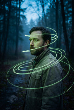 Portrait with glowing light swirl in dark night forest