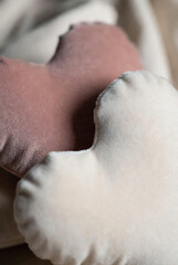 Naklejka premium Soft, plush pillows in shades of dusty rose and cream are visible in a close-up shot.
