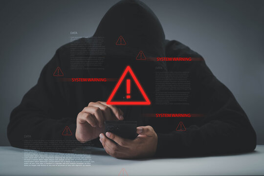 hacker using smartphone with system warning alert overlay, cybercrime and mobile security threat concept data breach, online fraud, identity theft, digital privacy risk, cybersecurity attack