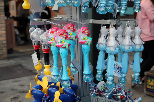
Toy bubble wands for children featuring the characters Ariel the Mermaid, Mickey Mouse, and Olaf are for sale in a store