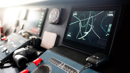 Digital GPS navigation monitor screen with VHF Radio, marine radar system and binoculars on modern boat dashboard in wheelhouse or ship captain bridge. Nautical vessel technology © zephyr_p
