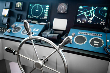 Wheelhouse steering console with digital dashboard of GPS navigation monitor, marine radar system, VHF Radio and binoculars in ship captain bridge or boat control room. Nautical vessel technology © zephyr_p