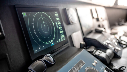 Digital dashboard with navigation monitor system, marine radar, VHF Radio and binoculars in ship captain bridge. Wheelhouse steering console on Nautical vessel transport. Modern boating technology © zephyr_p