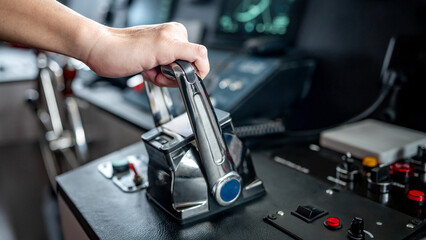 Captain hand holding throttle control or engine control lever on boat dashboard with GPS navigation and marine radar in wheelhouse or ship bridge. Speed adjustment instrument for seafaring technology © zephyr_p