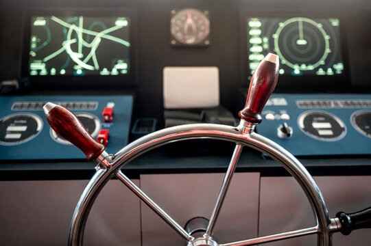 Wheelhouse steering console with digital dashboard of GPS navigation monitor, compass and marine radar system in ship captain bridge or boat control room. Nautical vessel technology