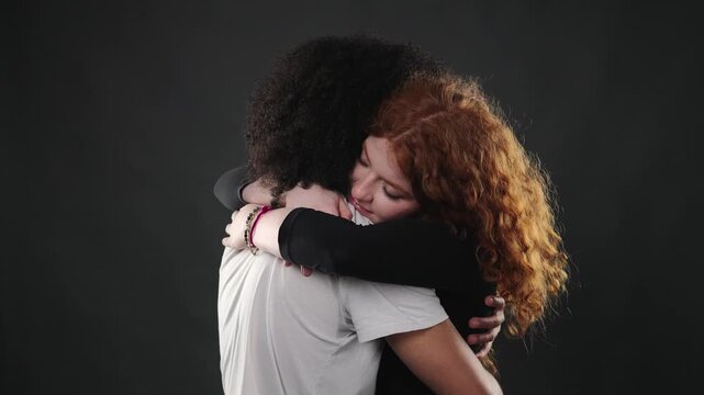A couple shares an intimate hug, conveying deep affection and mutual support. This close up studio shot on a dark background emphasizes their emotional connection and is projects exploring themes of l