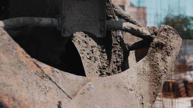 Concrete mixer drum chute covered with wet cement at construction site