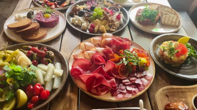 Shared brunch grazing boards with wings, charcuterie and fresh vegetables on wooden table, vibrant platters ideal for group dining and casual weekend