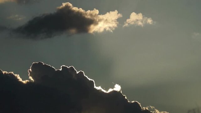 Cinematic silver lining clouds at sunset, dramatic storm clouds with golden light, ethereal sky background for weather and nature documentaries