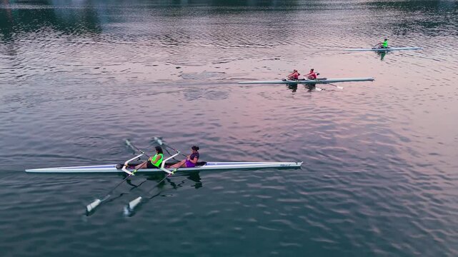 Early morning in Halifax, young athletes train on a calm ocean bay. Rowing singles and doubles, they glide across tranquil waters, preparing for upcoming competitions as the sun rises