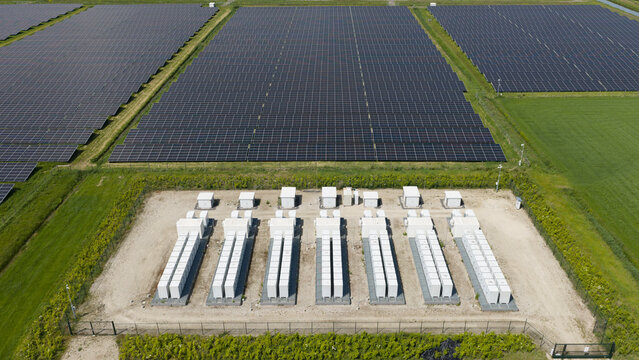Aerial view of solar panels and battery storage units surrounded by green fields in Wanneperveen, Overijssel, Netherlands.