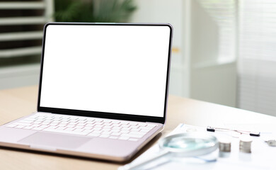 Fototapeta premium Modern laptop sits open on wooden desk. Blank screen invites customization or presentation design. Magnifying glass and ruler nearby suggest planning or analysis. Soft natural light enhances calm.