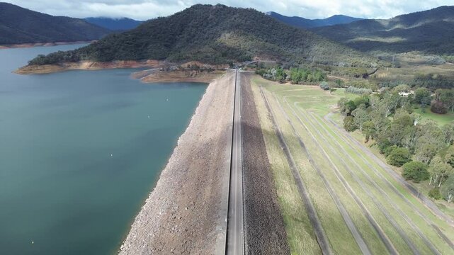 Aerial view flying over eildon dam wall and reservoir