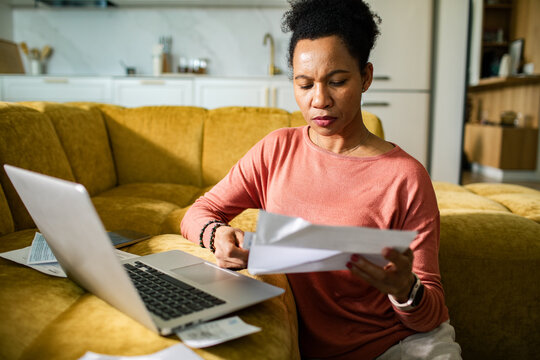 Woman paying bills on laptop at home