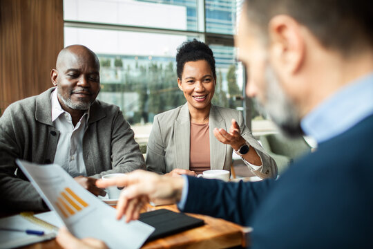 Smiling clients meeting with financial advisor at cafe