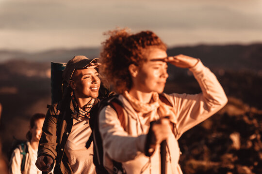Women hikers looking toward sunrise on mountain trail