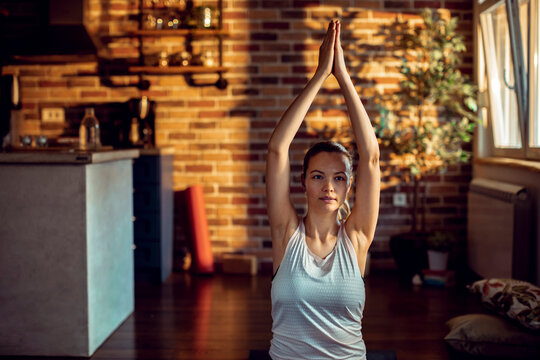 Young woman practicing yoga at home
