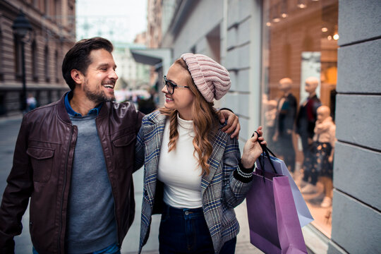 Happy couple shopping together on city street