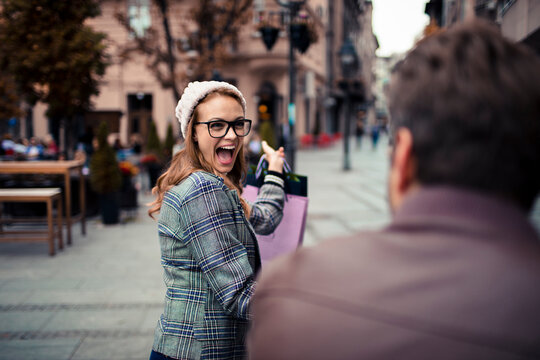 Excited woman with shopping bags on city street