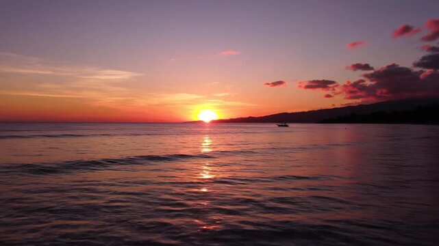 Beautiful sunset over the ocean with vibrant colors and calm waves.