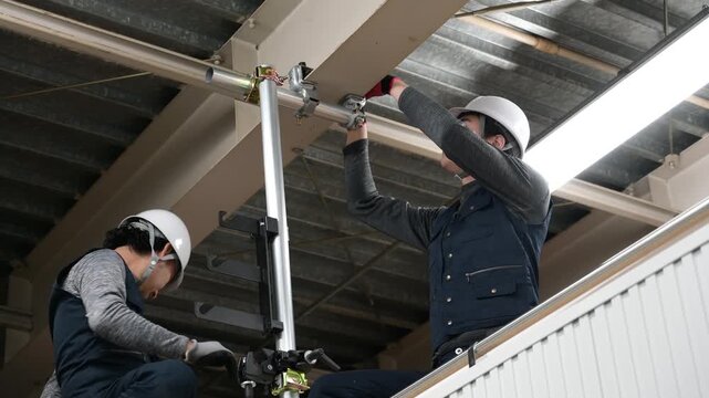 高所で単管パイプを設置する日本人男性作業員