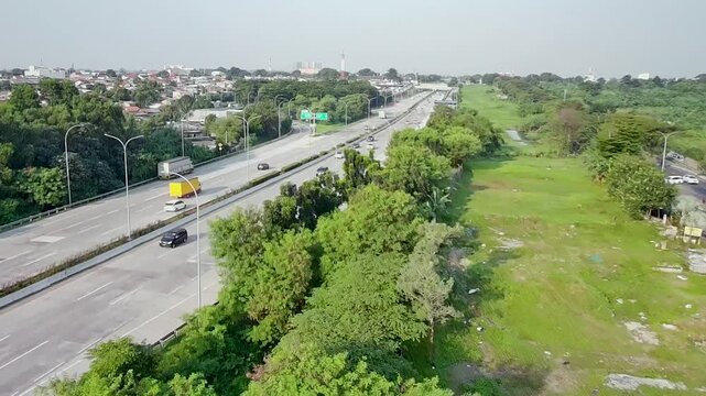 Aerial View of Urban Highway Traffic and Green Landscape in Daylight