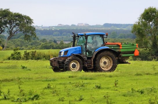 Centrifugal fertiliser spreader machine on a tractor. Agricultural equipment in County Antrim, Northern Ireland, UK.