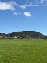 Fototapeta premium Fields with Norwegian Houses and Mountain Landscape