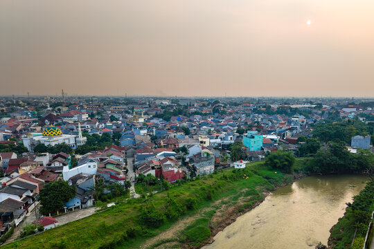 Smoggy sky hanging over dense urban housing and Bekasi river, Indonesia