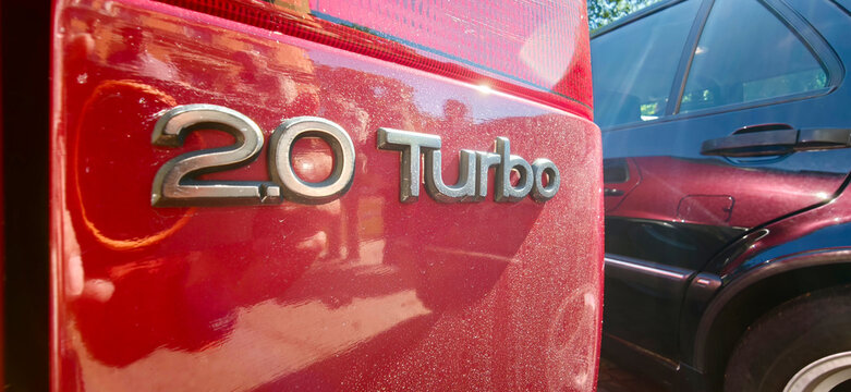 Saint Petersburg, Russia - May 23, 2026: Saab 2.0 Turbo badge on a red car with reflections of nearby vehicles and trees in the background