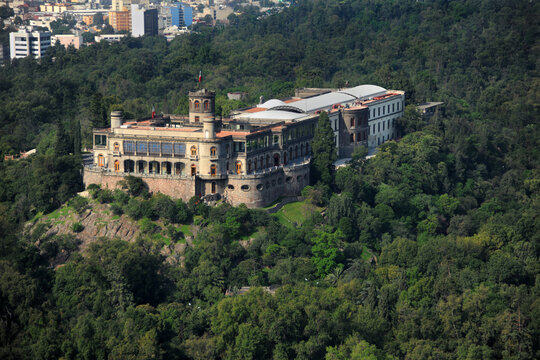Aerial view of Chapultepec Castle on a hill surrounded by the lush green forest of Chapultepec Park with the city skyline in Ciudad de Mexico, Ciudad de Mexico, Mexico.