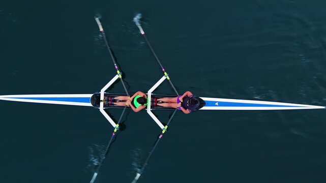 Dynamic teamwork unfolds as young women navigate the sparkling waters of Halifax Ocean Bay. They expertly maneuver a two-seater rowing boat, showcasing their skill and passion for water sports