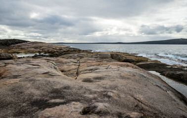 Fototapeta premium Granite rock formations overlooking calm bay waters in Two Peoples Bay Nature Reserve, Albany, Western Australia, 3 July 2024