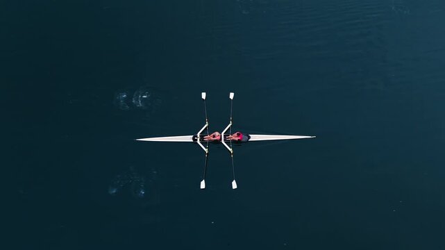In Halifax Ocean Bay, a team of young women athletes gracefully maneuvers a two-seater rowing boat. Their training showcases skill and teamwork on the serene water