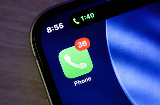 Closeup of an iphone screen showing the phone app icon with a notification badge indicating 36 missed calls and an active call timer