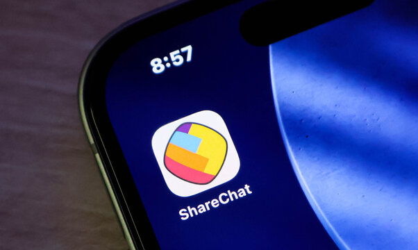 Closeup of the sharechat social media app icon on a smartphone screen, displaying the colorful logo against a dark blue background