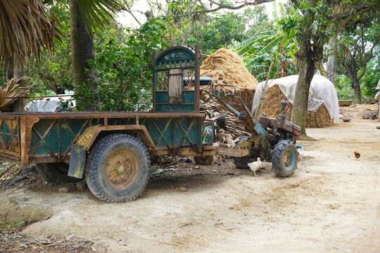 A traditional power tiller trolley parked in a rural village courtyard