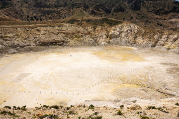 Blick in den tiefen  Stefanuskrater des Vulkans der griechischen  Insel Nissiros  mit Personen im Krater-  © Thomas