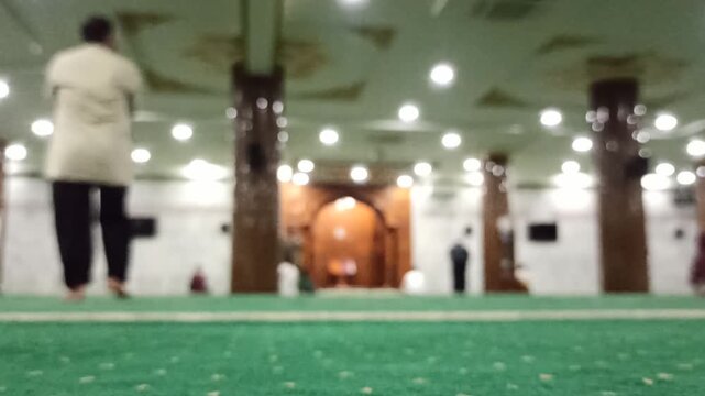 Artistic blur and defocus view inside a mosque during Maghrib prayer time, creating a peaceful spiritual atmosphere with soft evening lighting.