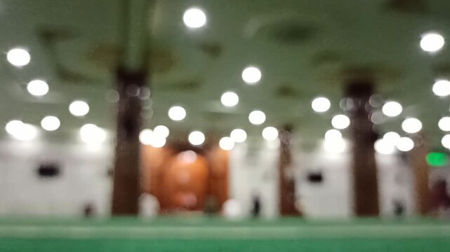 Artistic blur and defocus view inside a mosque during Maghrib prayer time, creating a peaceful spiritual atmosphere with soft evening lighting.