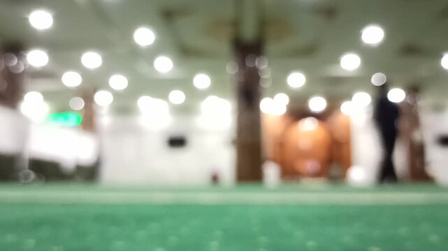 Artistic blur and defocus view inside a mosque during Maghrib prayer time, creating a peaceful spiritual atmosphere with soft evening lighting.