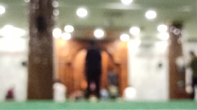 Artistic blur and defocus view inside a mosque during Maghrib prayer time, creating a peaceful spiritual atmosphere with soft evening lighting.