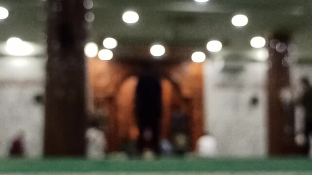 Artistic blur and defocus view inside a mosque during Maghrib prayer time, creating a peaceful spiritual atmosphere with soft evening lighting.