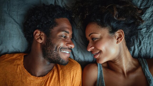 A happy couple in love communicate face-to-face while relaxing in bed.