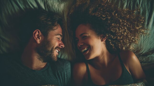 A happy couple in love communicate face-to-face while relaxing in bed.
