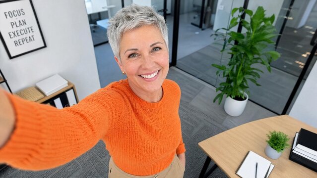 Happy Mature Businesswoman with Grey Hair Taking Selfie in Modern Office