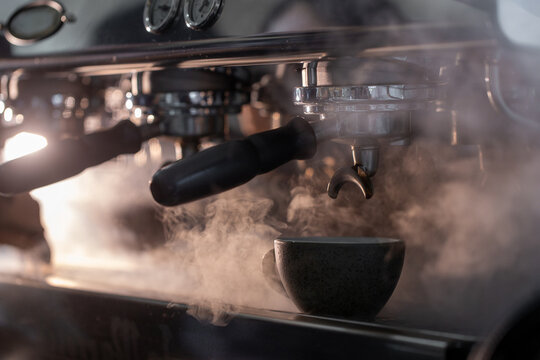 Professional espresso machine brewing fresh coffee with hot steam