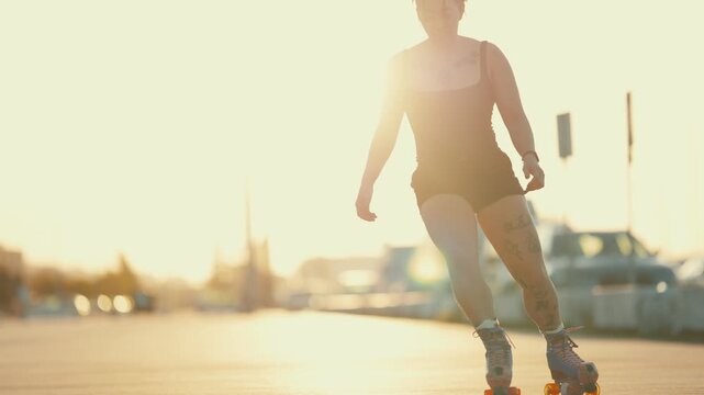Tattooed woman roller skating down an empty street at sunset