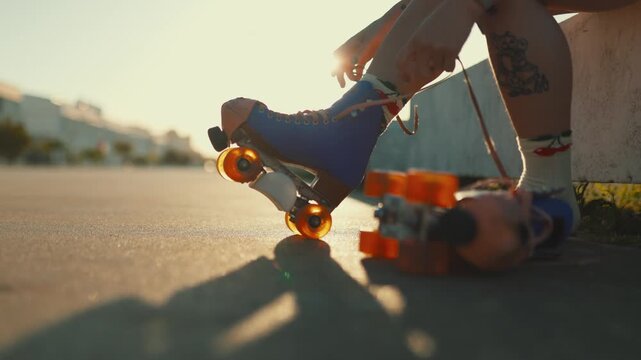 Tattooed woman putting on retro roller skates at sunset