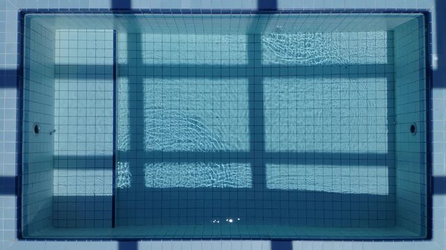 Top view of clear blue water ripples in a tiled indoor swimming pool